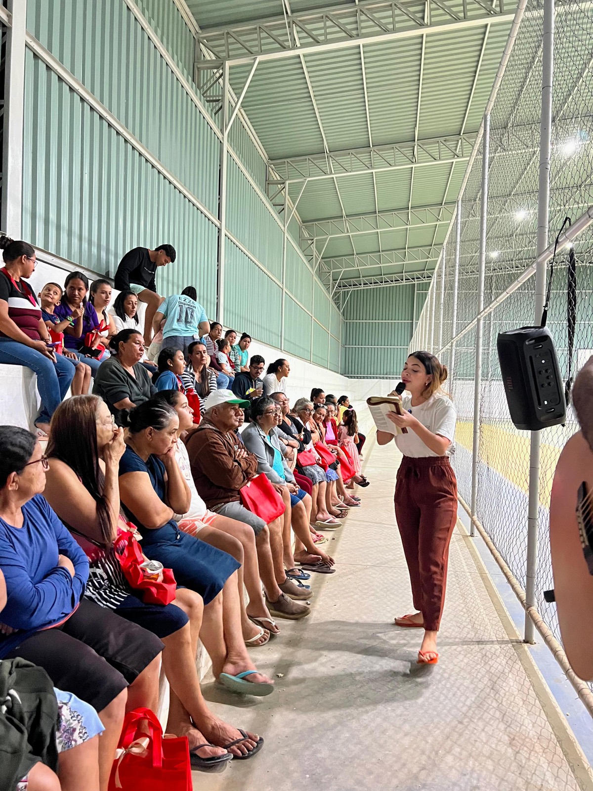 Voluntária lê a Bíblia para a comunidade durante ação do projeto em Sertânia